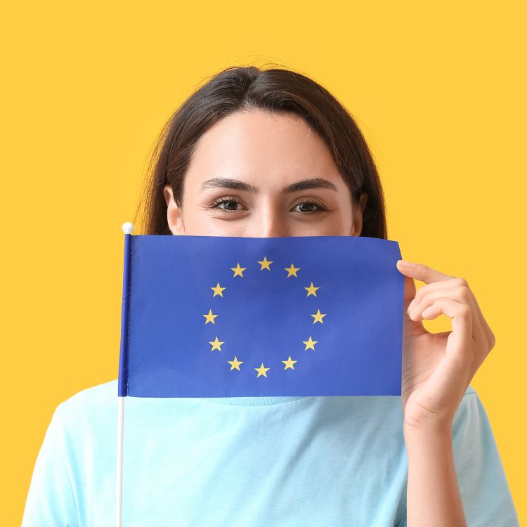 Menu-item over de EAA wordt grafisch weergegeven door een jonge vrouw die de EU-vlag half voor haar gezicht houdt.
